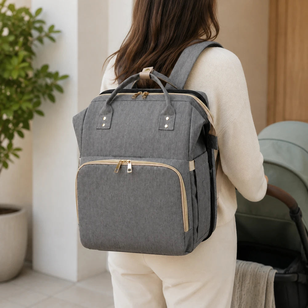 Pessoa usando mochila maternidade cinza ao lado do carrinho de bebê